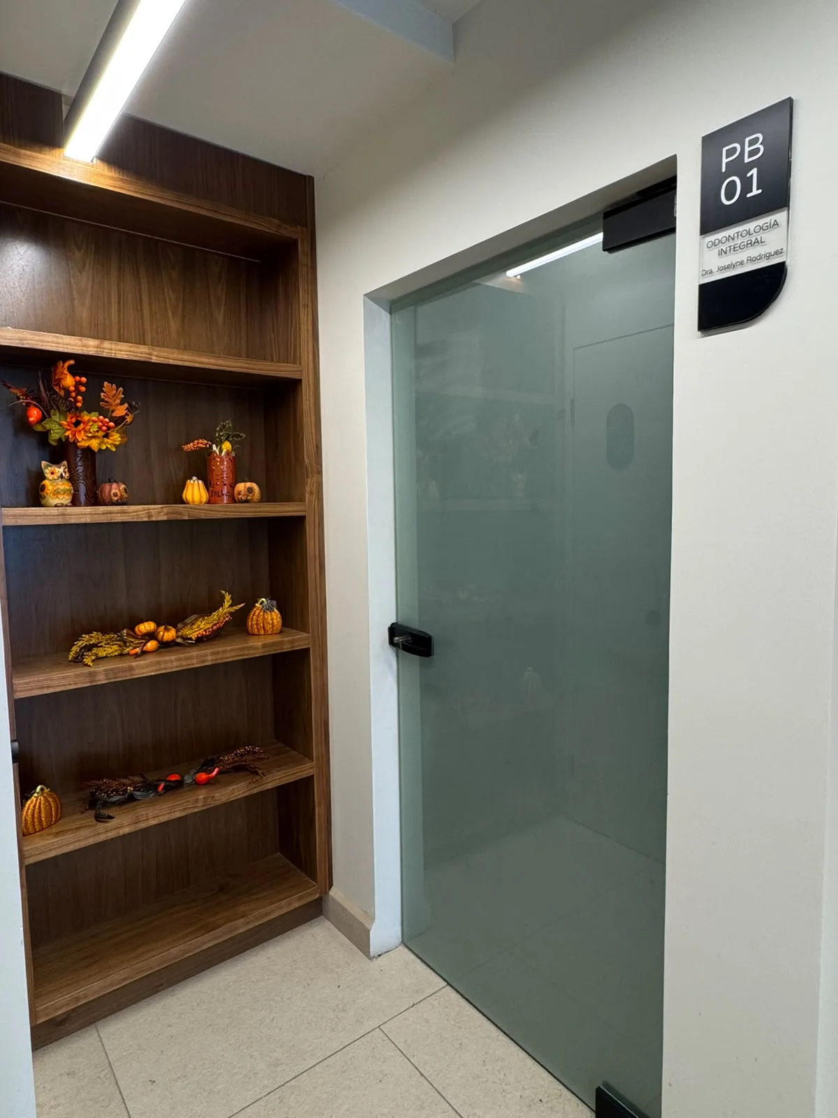 Puerta de cristal del consultorio con la placa PB 01, Odontología Integral