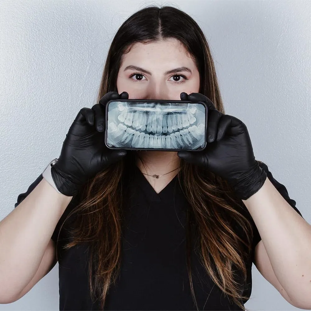 La Dra. Joselyne sosteniendo una radiografía panorámica digital